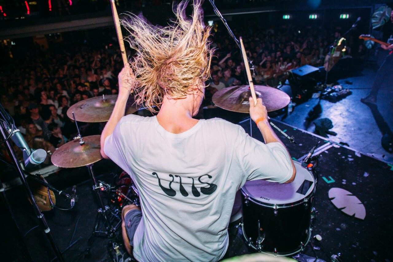 Selina's Iconic Venue Experience: Close-Up Flash Photo of Hockey Dad Drummer in Action on Stage